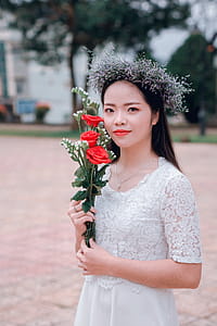 Selective Focus Photography of Woman Holding Three Red Rose Flowers thumbnail