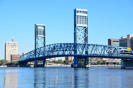 gray concrete bridge across body of water near high-rise buildings at daytime thumbnail