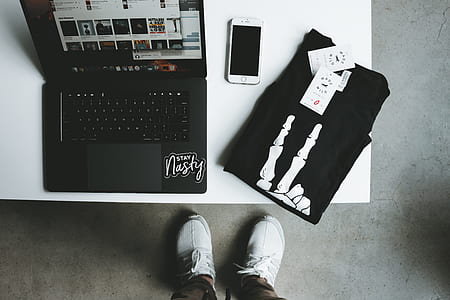 MacBook near iPhone and T-shirt on table thumbnail