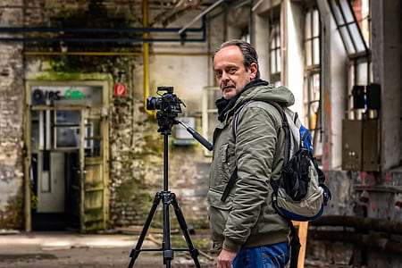 man standing near black tripod thumbnail