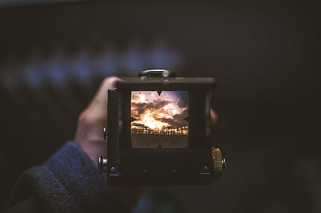 person holding black digital camera thumbnail