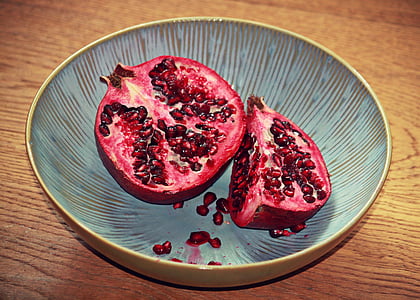 sliced of pomegranate inside brown bowl thumbnail