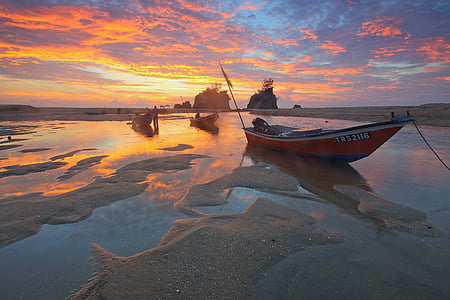 red and blue boat on body of water during sunset thumbnail
