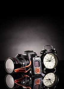 black Canon EOS DSLR camera near black bell alarm clock thumbnail