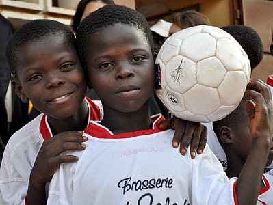 two boy wearing white t-shirt holding soccer ball thumbnail