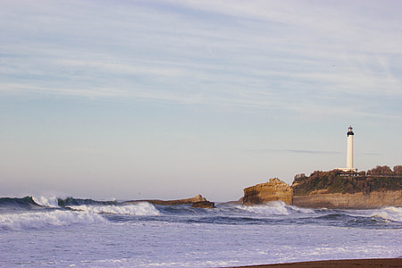 time lapse photography of white and black lighthouse near body of water thumbnail