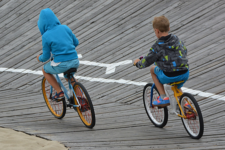 two boys riding on a bicycle during daytime thumbnail