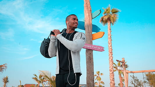 Boy Carrying Black Duffel Bag While Listening thumbnail
