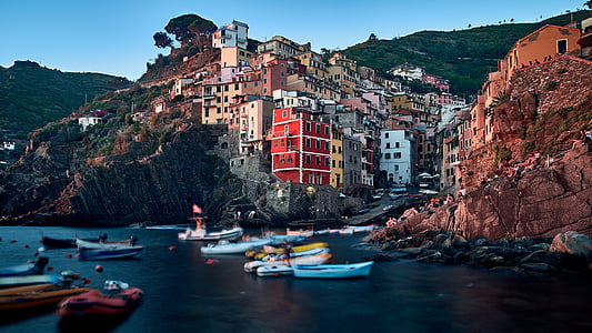 assorted-color boat on body of water near building at daytime thumbnail