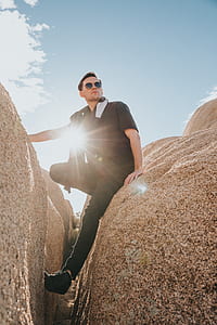 man sitting on rock during daytime thumbnail