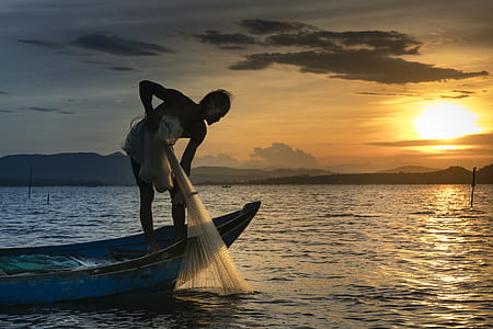 person riding row boat while holding fishing net thumbnail