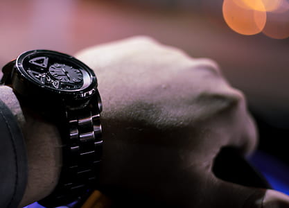 person wearing round black chronograph watch with link bracelet thumbnail