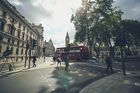 people passing on pedestrian walk near red bus thumbnail