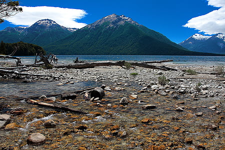 photo of mountain near seashore under blue sky at daytime thumbnail