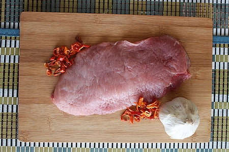 raw meat on brown wooden chopping board thumbnail