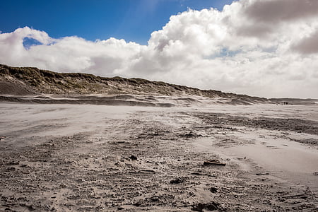 seashore near mountain range under nimbus clouds thumbnail