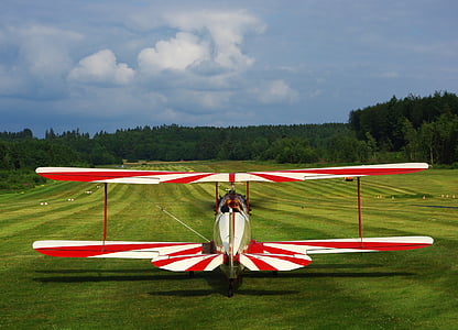 red and white striped biplane on ground thumbnail