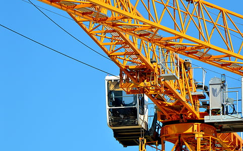 white cable car beside orange crane during daytime thumbnail