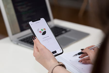 person holding space gray iPhone X and ballpoint pen thumbnail