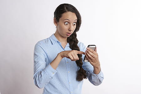 woman wearing blue button-up collared long-sleeved shirt golding gold iPhone 5s with black bumper case thumbnail