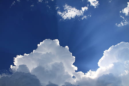 sunlight piercing through white clouds during daytime thumbnail