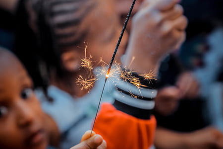 selective focus photo of person holding gray sparkler thumbnail