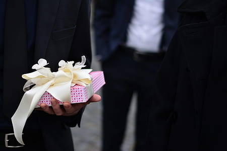 person holding pink and white gift box thumbnail