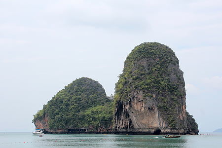yacht near island with trees thumbnail