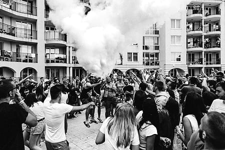 grayscale photography of people gathered in front of concrete structures thumbnail