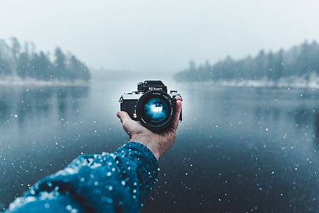 person holding DSLR camera thumbnail