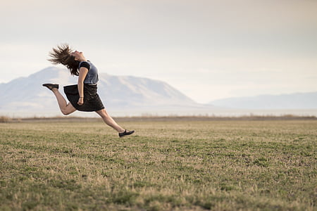 woman wearing black and gray mini dress above grass field thumbnail