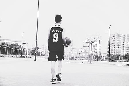 grayscale photography of man wearing basketball jersey shirt holding basketball ball thumbnail
