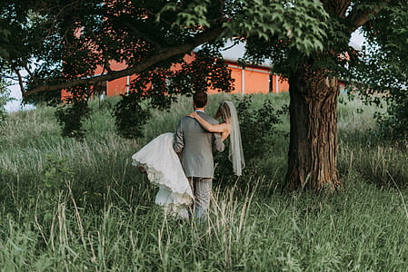 man carrying woman near tree thumbnail