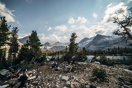 man sitting on rock looking at river thumbnail