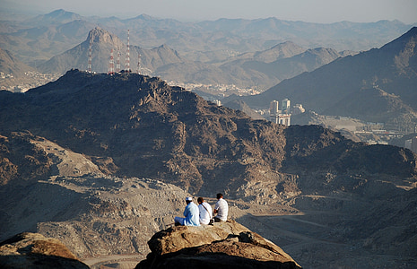 three person sitting of cliff at daytime thumbnail
