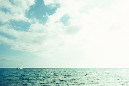 boat on ocean under cloudy sky thumbnail