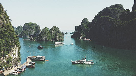motorboats on body of water with mountains thumbnail