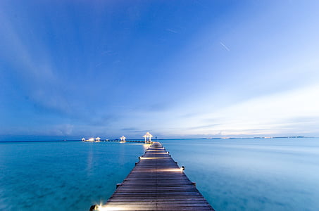 brown dock on blue body of water during daytime thumbnail