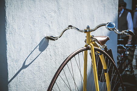 yellow city bicycle beside white wall thumbnail