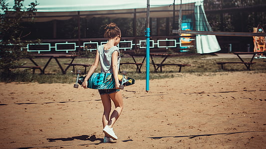 woman in gray shirt holding longboard thumbnail