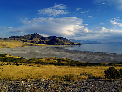 blue sea near mountain under cloudy sky thumbnail