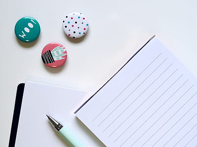 three button pins beside white ruled paper thumbnail