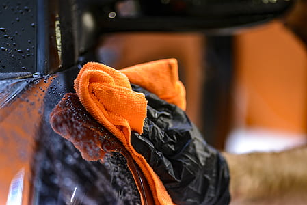 man wearing black gloves holding orange towel thumbnail