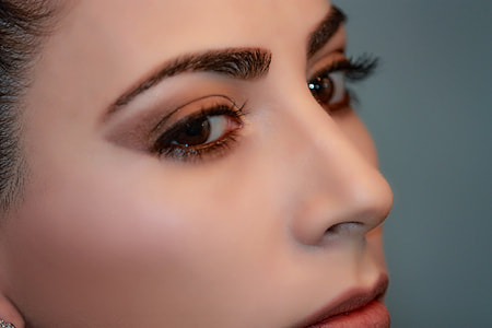 closeup photo of woman with red lipstick, brown eyeshadow and black eyebrow thumbnail