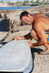 man holding white surfboard thumbnail