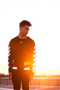 man wearing black sweatshirt standing during golden hour thumbnail