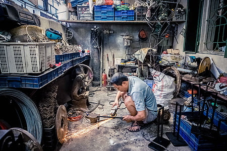 man using angle grinder on gray wrough iron bar thumbnail