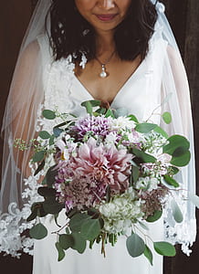 woman wearing wedding gown and holding bouquet of flowers thumbnail