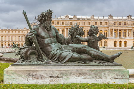 man holding sword beside two cherub statue thumbnail