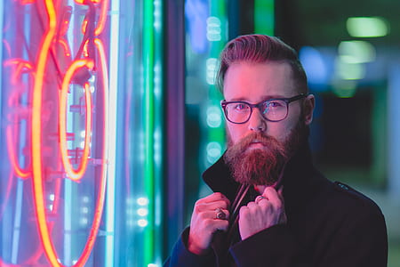 man holding jacket near neon signage wall reflect in face thumbnail